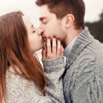 Young couple outdoor portrait. pretty girl kissing handsome boy